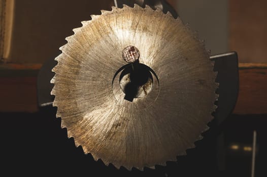 Metal circular saw blade on a wooden background. top view. work tool. carpentry instrument