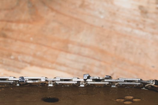 Chainsaw bar and cutting chain close up. blade of a chainsaw on a wooden background. copy space