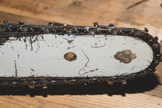 Chainsaw bar and cutting chain close up. blade of a chainsaw on a wooden background