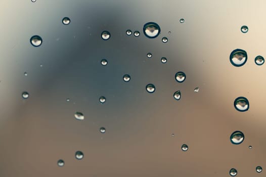 Raindrops on window glass close up. water drops macro background