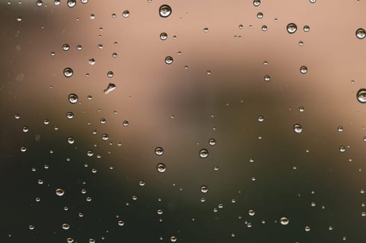 Raindrops on window glass close up. water drops macro background