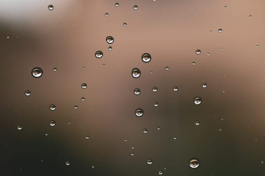 Raindrops on window glass close up. water drops macro background