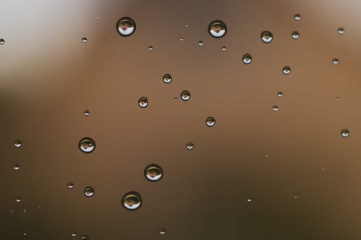 Raindrops on window glass close up. water drops macro background