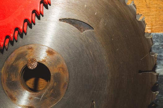 Metal circular saw blade on a wooden background. top view. work tool. carpentry instrument
