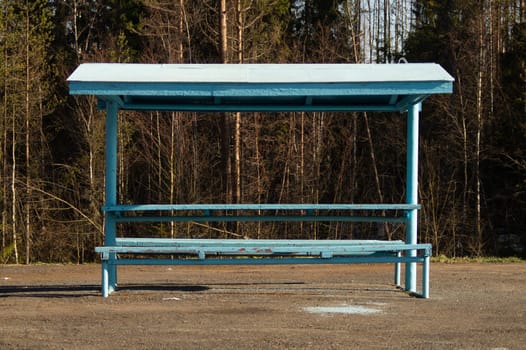 Rural bus stop on the country road with the forest on the background