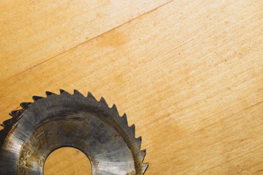 Metal circular saw blade on a wooden background. top view. work tool. carpentry instrument. copy space