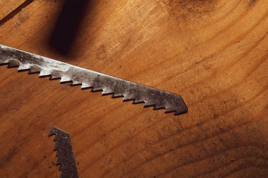Old hand saw on a dirty wooden background. working area with hand tool. carpentry instrument. manual labor concept