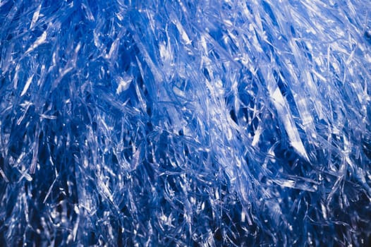 Abstract blue texture with wavy plastic stripes. blue tinsel macro