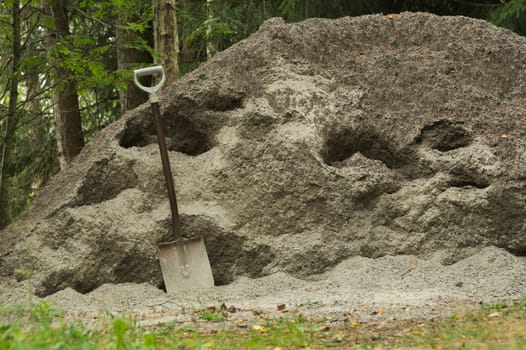 Shovel placed on a sand hill. manual labor background