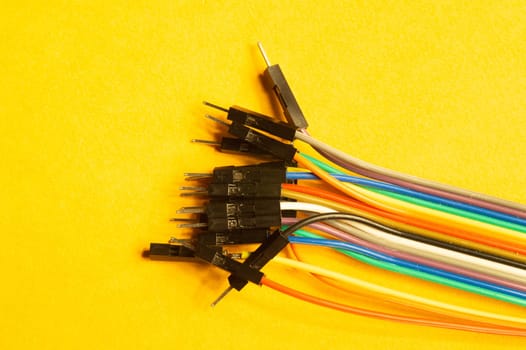 Colorful wires isolated on yellow background. connection wire for electrical schemes and devices. copy space