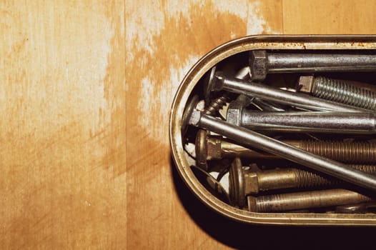 Old screws in a box. a lot of various screws. pile of fasteners in the box close up. carpentry workshop. work tool
