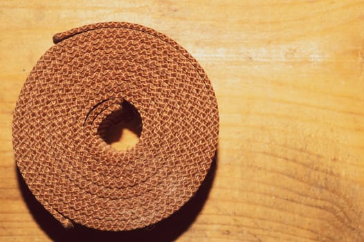 Industrial harness rolled up on a wooden table. work tool