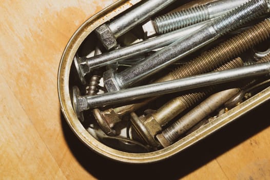 Old screws in a box. a lot of various screws. pile of fasteners in the box close up. carpentry workshop. work tool