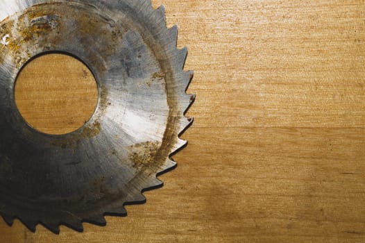 Metal circular saw blade on a wooden background. top view. work tool. carpentry instrument. copy space