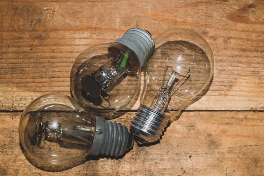 Light bulb on a wooden background. old lamp lies on the table.