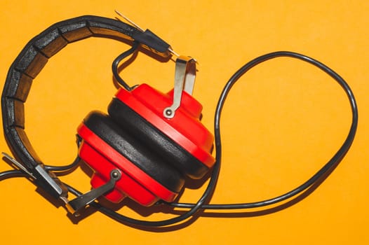 Vintage red headphones on yellow background. retro earphones
