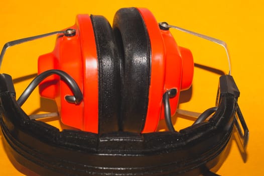 Vintage red headphones on yellow background. retro earphones