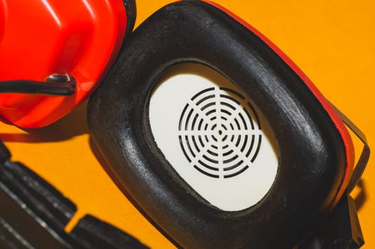 Vintage red headphones on yellow background. retro earphones