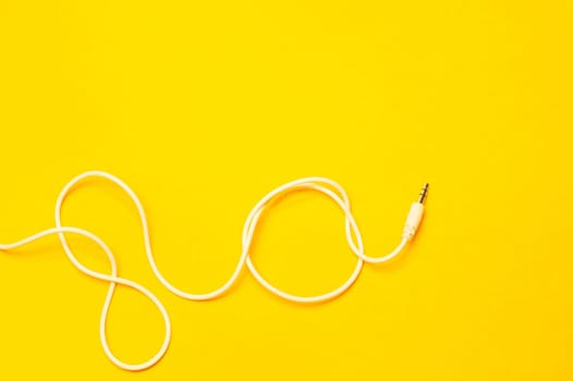 Audio jack with white cable isolated on yellow background