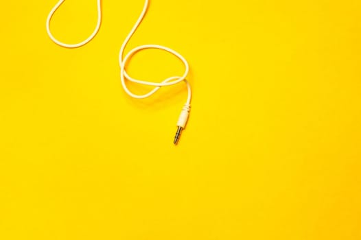 Audio jack with white cable isolated on yellow background