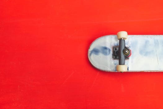 Small skateboard on red background. tiny skate for fingers. fingerboard close up. copy space