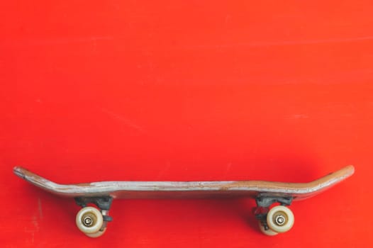 Small skateboard on red background. tiny skate for fingers. fingerboard close up. copy space