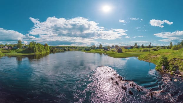 Village by the river. countryside panorama. water surface. rural landscape with houses on the shore. summer day