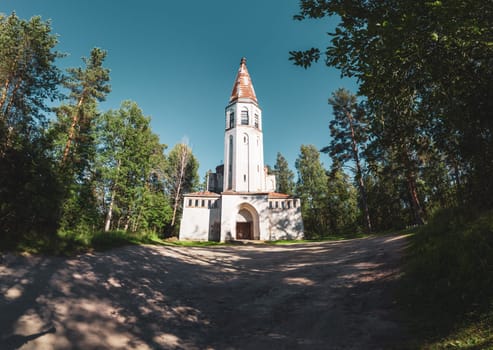 Old wooden church among the overgrown field. rural panoramic landscape. roof of ancient chapel