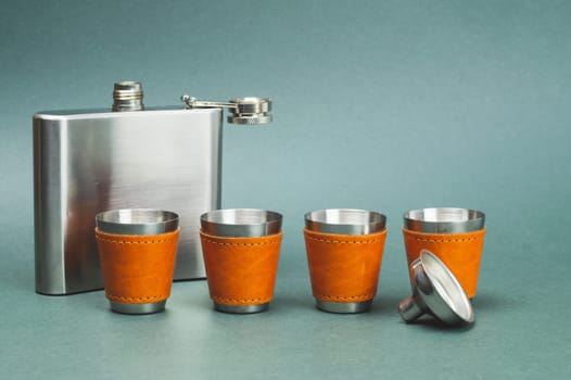 Metallic flask. shot glasses with funnel. travel shot glass for alcohol with leather casing over the stainless steel. personal accessory set. copy space