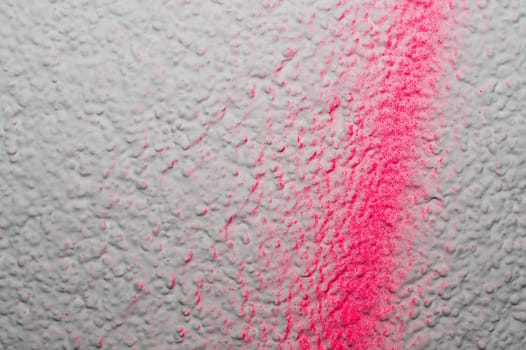 Uneven wall with red splashes of paint. rough surface. painted concrete texture