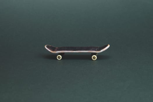 Small skateboard on color background. tiny skate for fingers. fingerboard close up. copy space