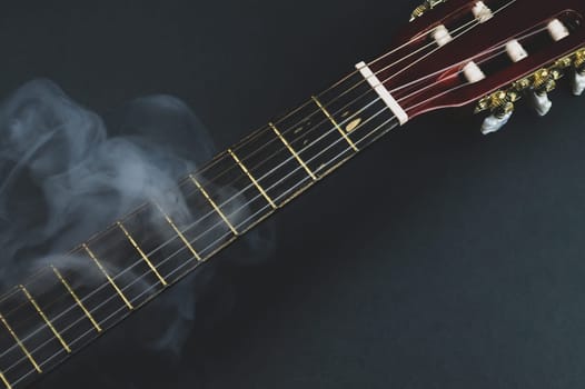 Guitar fretboard in smoke close up. musical instrument. strings on the guitar neck