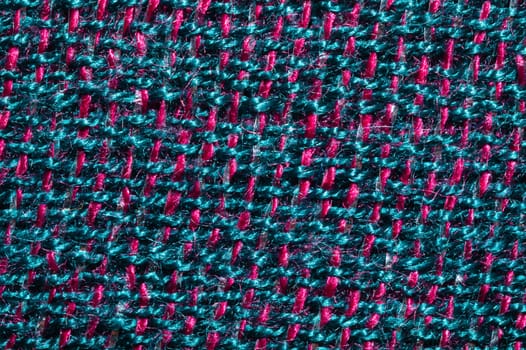 Fabric macro texture. knitted textile. woven background. woolen material. weaving blue and red threads close up