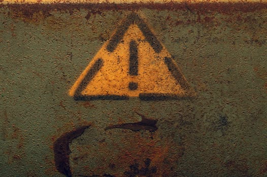 Attention sign in yellow triangle on rusty metal background. exclamation symbol with grunge backdrop