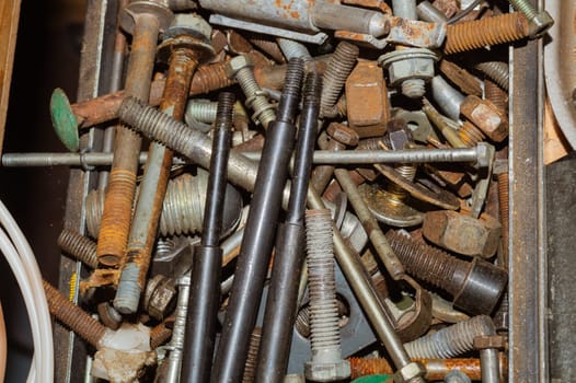 Pile of fasteners and screws close up. scrap metal. different metal parts. industrial background