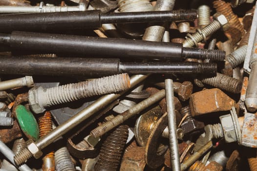 Pile of fasteners and screws close up. scrap metal. different metal parts. industrial background