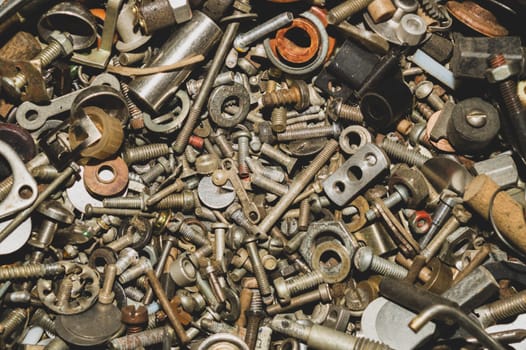 Pile of fasteners and screws close up. scrap metal. different metal parts. industrial background