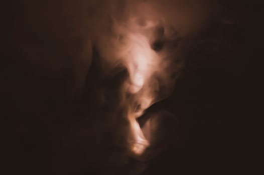 Colored smoke on black backdrop. brown fog abstract background