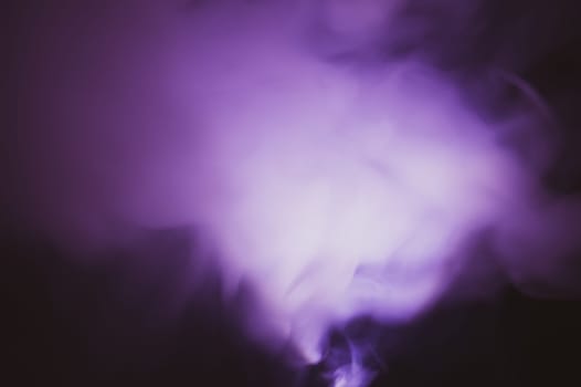 Violet smoke on black backdrop. color fog abstract background