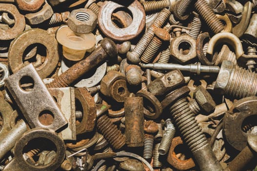 Pile of fasteners and screws close up. scrap metal. different metal parts. industrial background