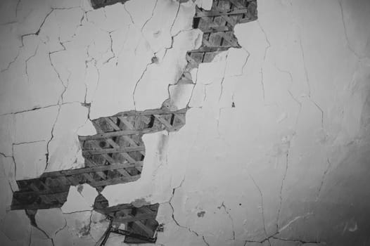 Dilapidated ceiling of an old house. damaged wall with a hole with timber frame. abstract background of ruined surface