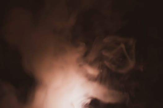 Colored smoke on black backdrop. brown fog abstract background