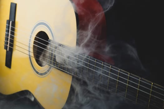 Guitar in smoke close up. musical instrument. strings on the guitar fretboard