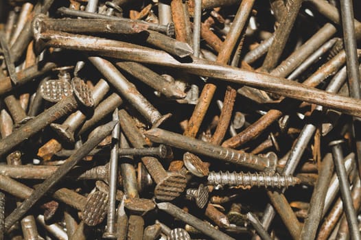Pile of fasteners and screws close up. scrap metal. different metal parts. industrial background