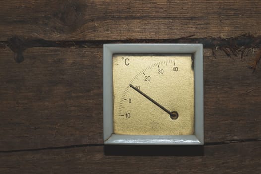 Vintage thermometer hanging on a wooden wall. celsius scale with degrees. indoor temperature measurement