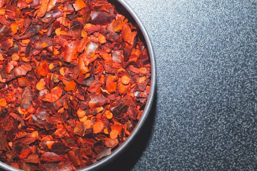 Dried chili pepper in the jar. hot spice. red seasoning background. copy space