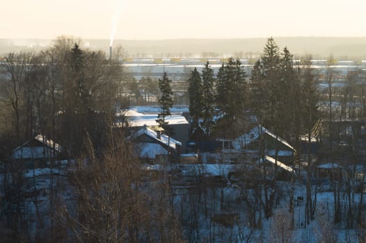 Snow covered houses with the gardens in winter. wooden houses in the forest aerial view. rural landscape from high view