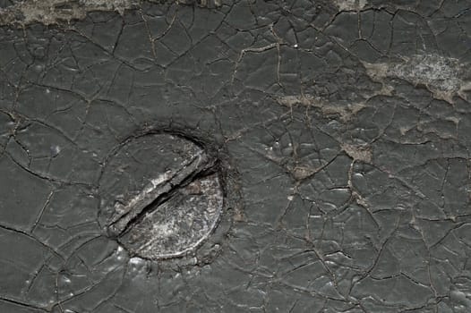 Cracked black coating on wooden surface. grunge background. metal nail covered with paint. shabby wood texture. spots and scratches