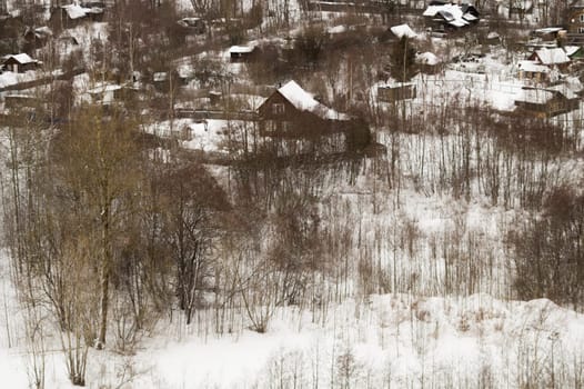 Snow covered houses with the gardens in winter. wooden houses in the forest aerial view. rural landscape from high view