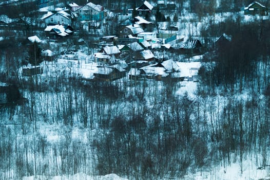 Snow covered houses with the gardens in winter. wooden houses in the forest aerial view. rural landscape from high view